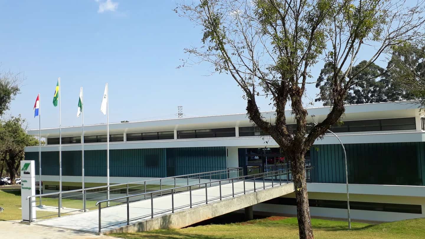 Fachada do Centro de Tecnologia da Klabin, em Harmonia (PR), com mastro de bandeiras em primeiro plano.