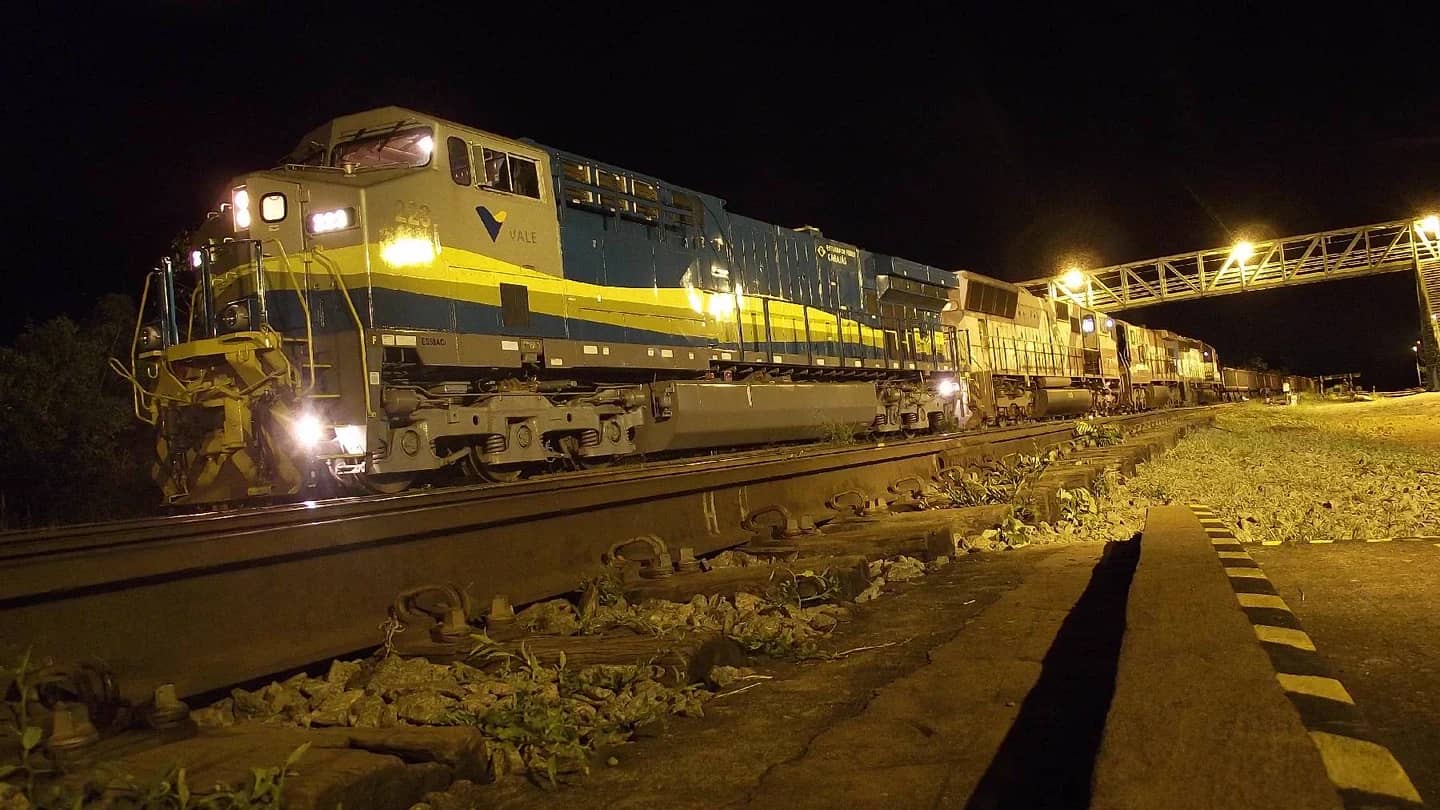 Locomotiva da Vale com composicao de vagoes carregados de minerio de ferro ao anoitecer