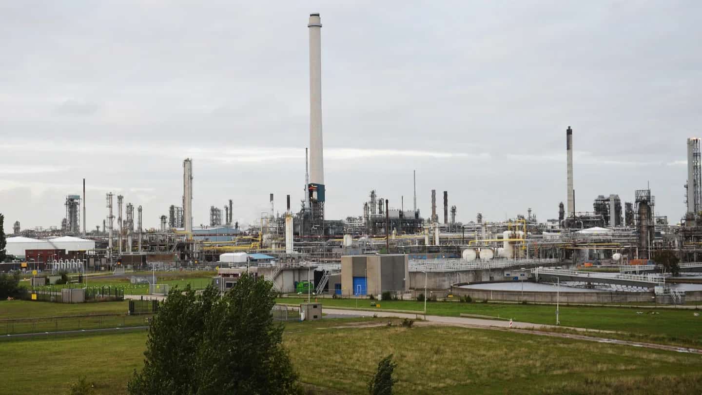Vista da refinaria da Shell em Pernis, nos Países Baixos, com torres de destilação e chaminé ao fundo