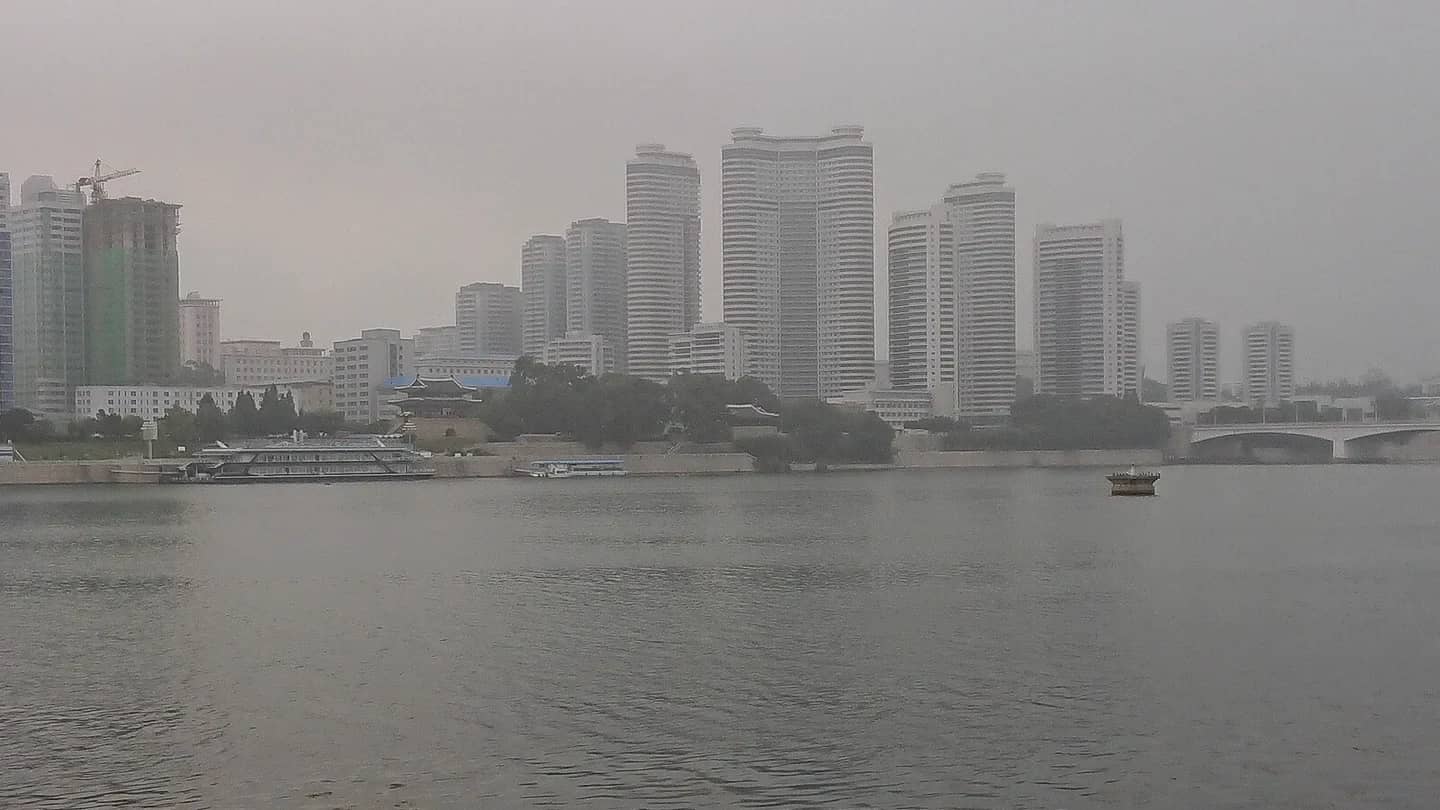 Vista da linha de horizonte de Pyongyang, na Coreia do Norte, com edifícios altos e torre ao fundo