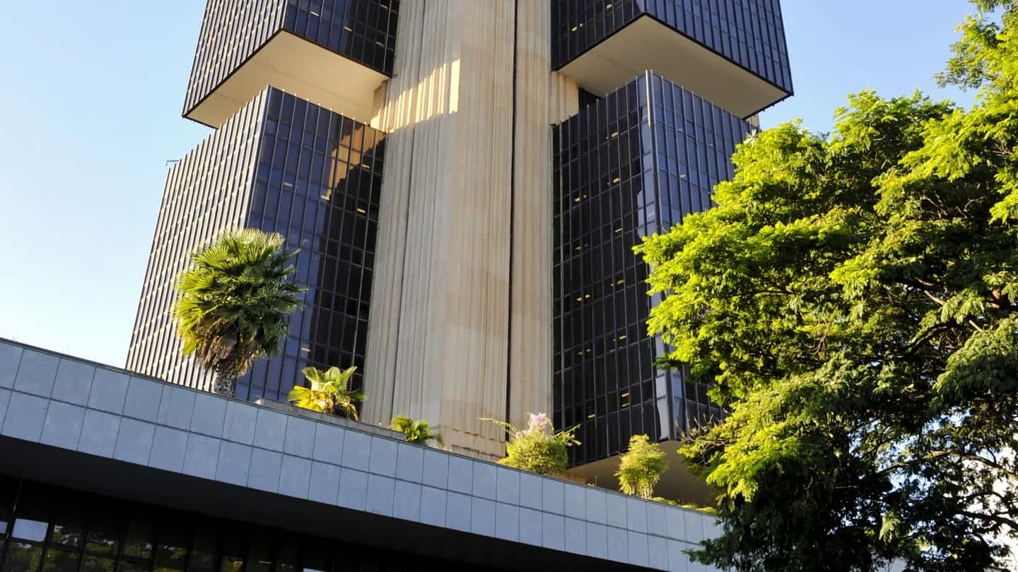 Edifício-sede do Banco Central do Brasil, em Brasília, visto de baixo entre árvores