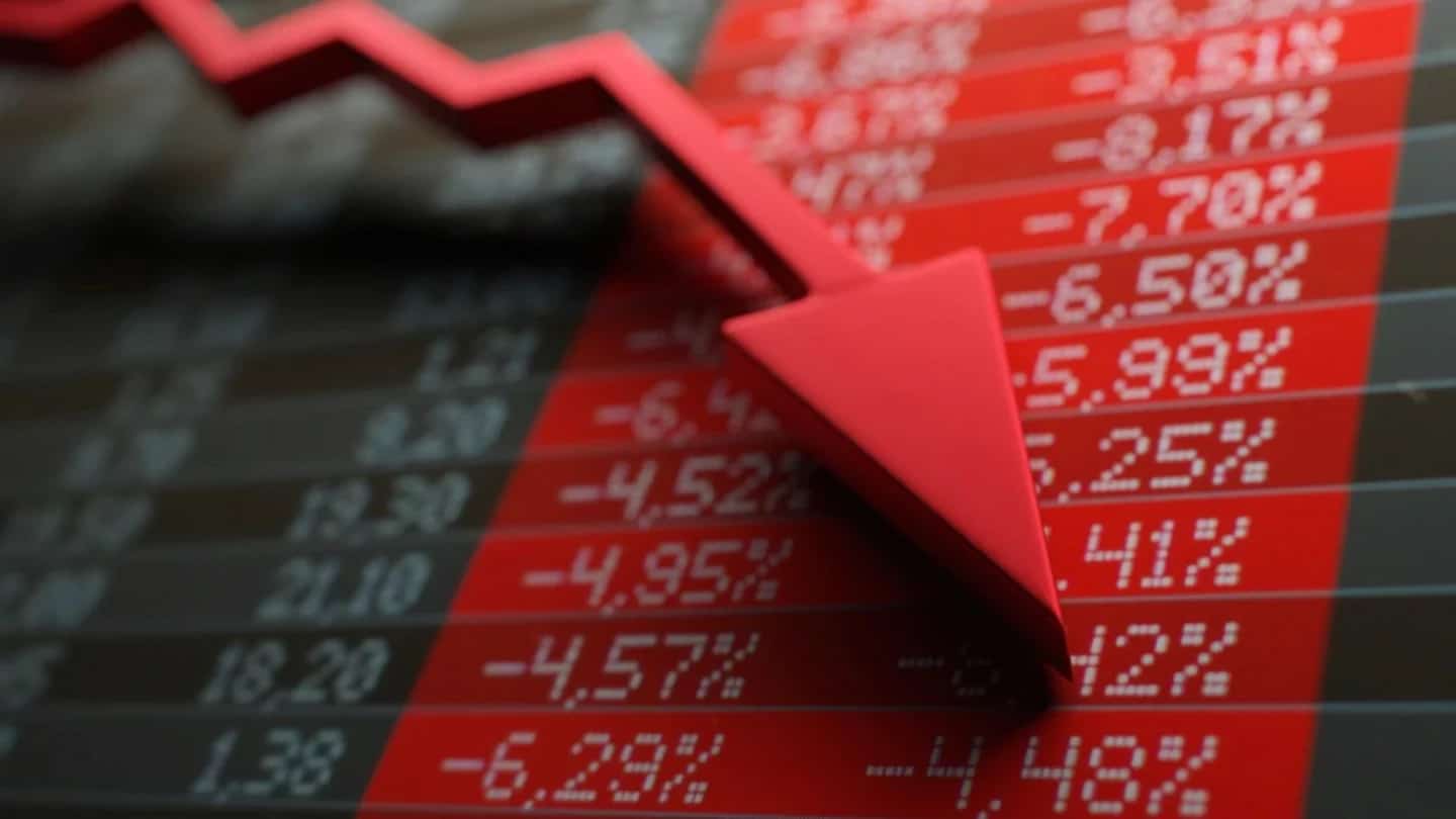 Seta vermelha de queda sobre painel de cotações da bolsa