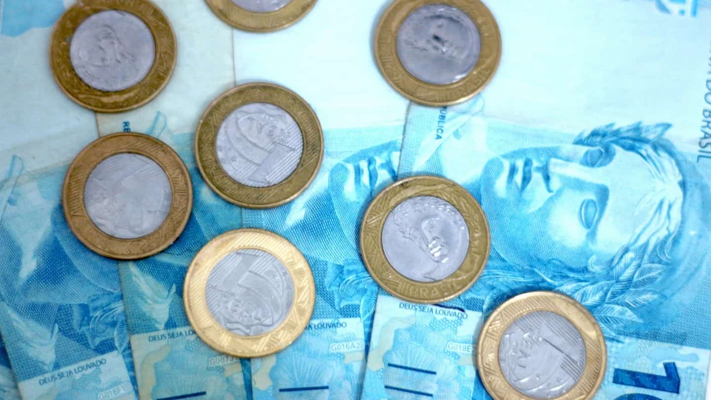 Moedas sobre cédulas, representando investimento em renda fixa