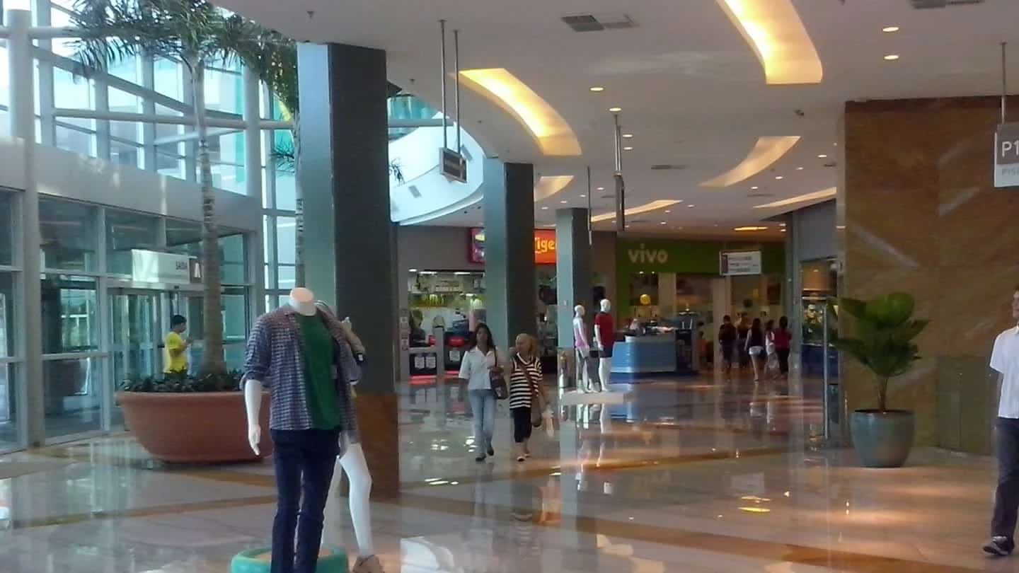 Interior de shopping center no Brasil, com corredores e lojas iluminadas